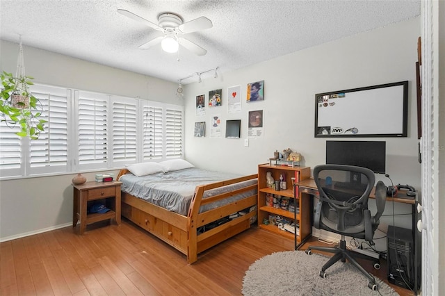 bedroom featuring a textured ceiling, hardwood / wood-style flooring, and ceiling fan