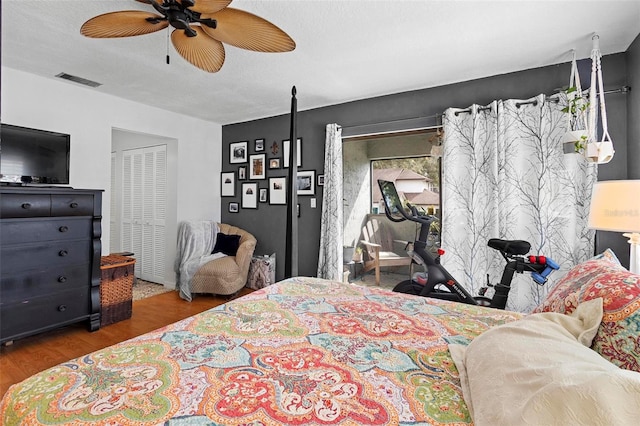 bedroom featuring a closet, a textured ceiling, hardwood / wood-style flooring, and ceiling fan