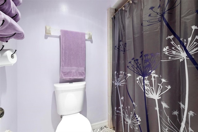 bathroom featuring curtained shower and toilet