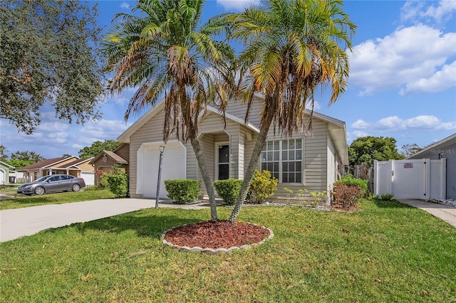 view of front of house with a front yard, fence, a garage, and driveway