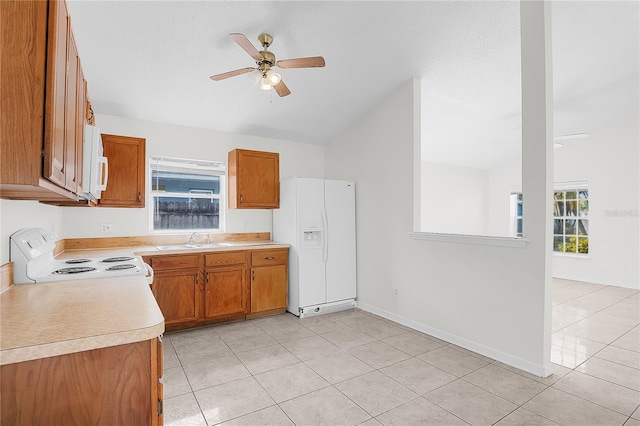 kitchen featuring white appliances, sink, light tile patterned floors, and ceiling fan