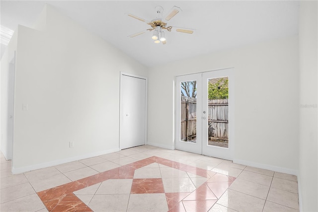 tiled empty room featuring lofted ceiling, french doors, and ceiling fan