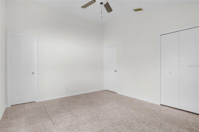 unfurnished bedroom with ceiling fan, light tile patterned floors, and a closet