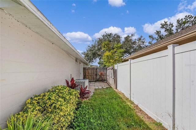 view of yard with central AC unit and a fenced backyard