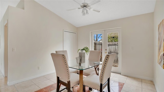 dining space with light tile patterned floors, a ceiling fan, baseboards, vaulted ceiling, and french doors