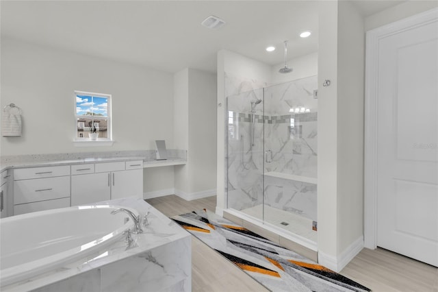 bathroom featuring hardwood / wood-style flooring, vanity, and independent shower and bath