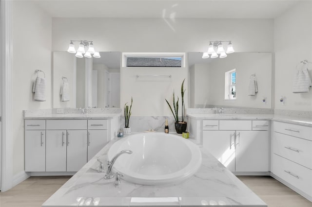 bathroom with vanity, a bath, and hardwood / wood-style flooring