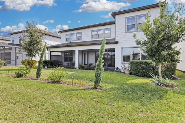 back of house with a sunroom and a lawn