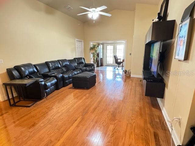 living room featuring french doors, hardwood / wood-style flooring, high vaulted ceiling, and ceiling fan