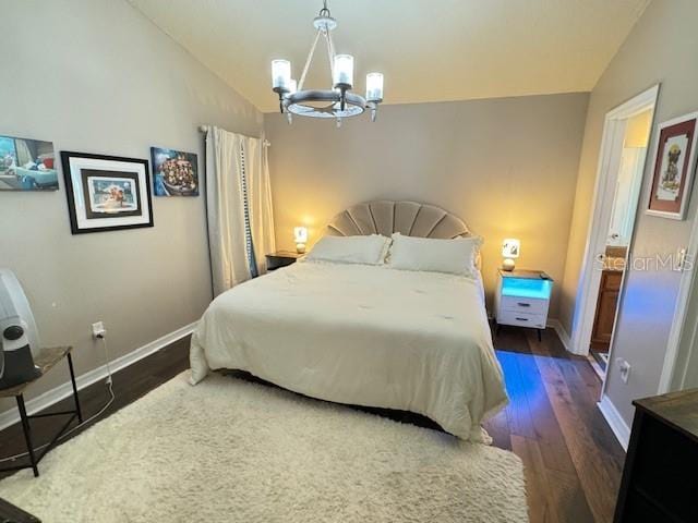 bedroom featuring dark hardwood / wood-style flooring, an inviting chandelier, and vaulted ceiling