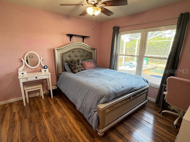 bedroom with ceiling fan and dark hardwood / wood-style floors