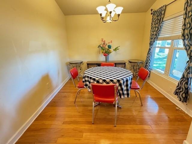 dining area featuring an inviting chandelier and light wood-type flooring