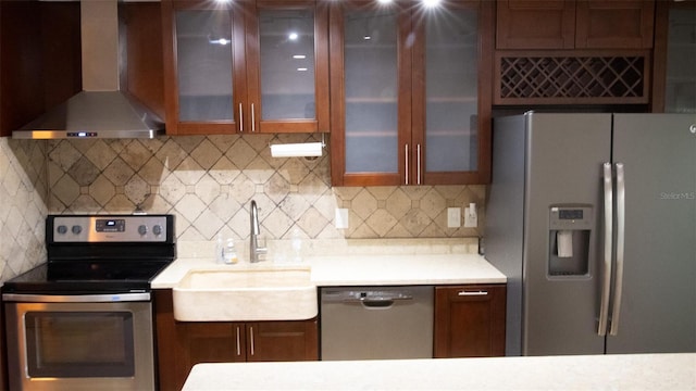 kitchen featuring backsplash, stainless steel appliances, wall chimney exhaust hood, and sink