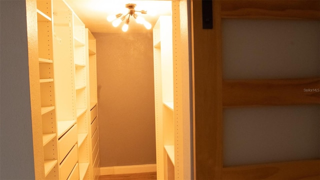 hallway featuring hardwood / wood-style flooring and an inviting chandelier