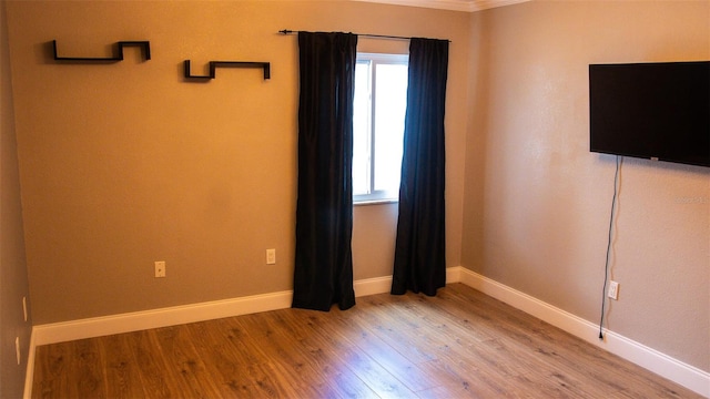 unfurnished room with ornamental molding, plenty of natural light, and light wood-type flooring