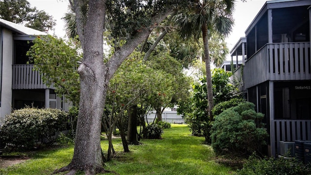 view of yard featuring a sunroom and a balcony