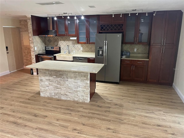 kitchen featuring sink, light wood-type flooring, a center island, and appliances with stainless steel finishes