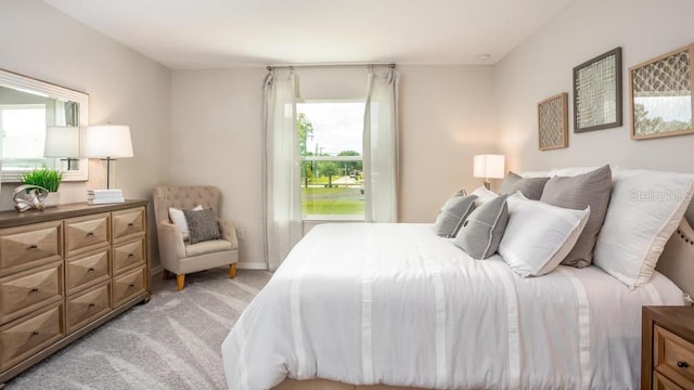 bedroom featuring light carpet and multiple windows