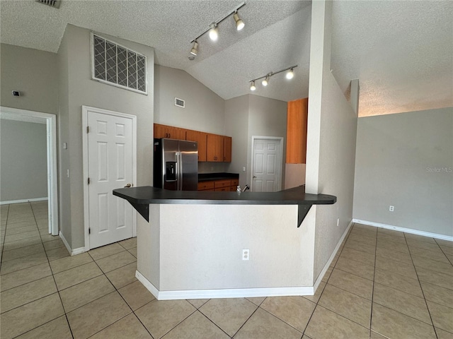 kitchen with kitchen peninsula, stainless steel fridge with ice dispenser, and a textured ceiling