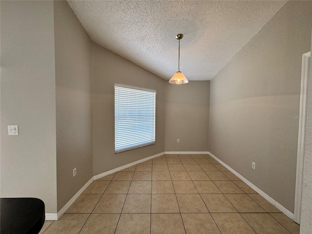 unfurnished dining area with lofted ceiling, light tile patterned floors, and a textured ceiling