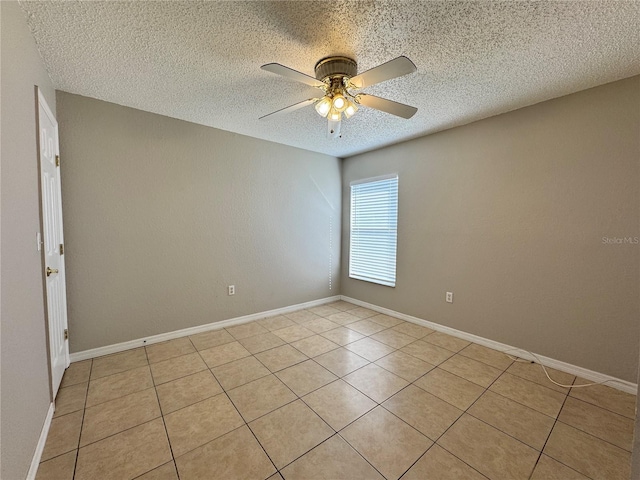 tiled empty room featuring ceiling fan and a textured ceiling