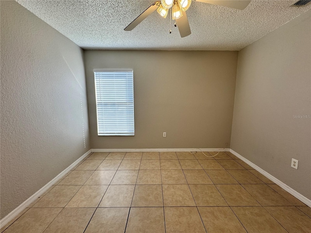 tiled empty room featuring ceiling fan and a textured ceiling