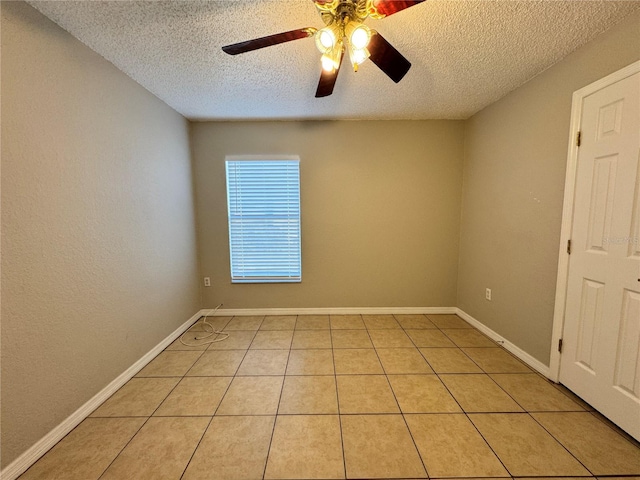 tiled empty room featuring ceiling fan and a textured ceiling