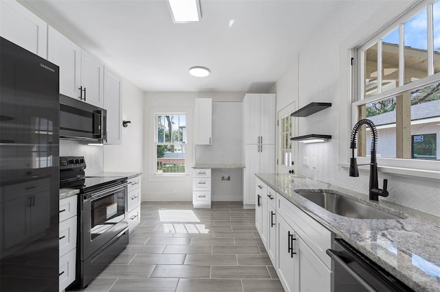 kitchen with white cabinetry, tasteful backsplash, black appliances, and sink