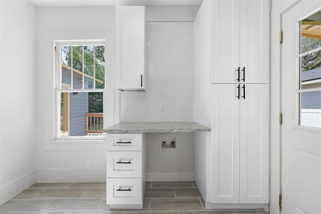 interior space with washer hookup, cabinets, and plenty of natural light