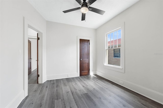 empty room with light hardwood / wood-style floors, a textured ceiling, and ceiling fan