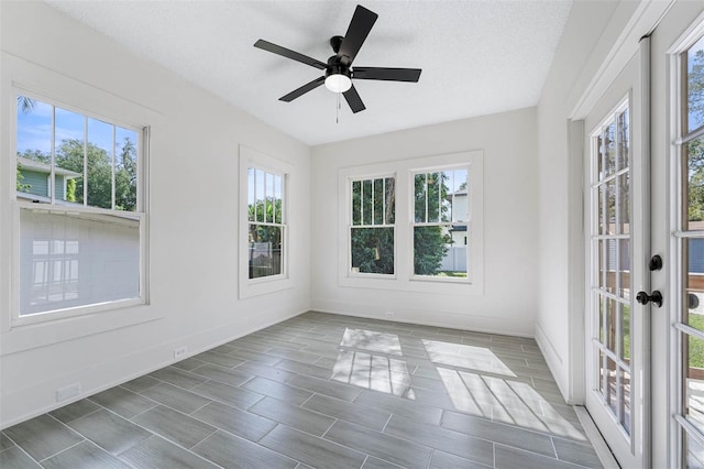 unfurnished sunroom featuring ceiling fan