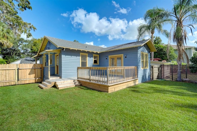 back of property with a wooden deck and a yard