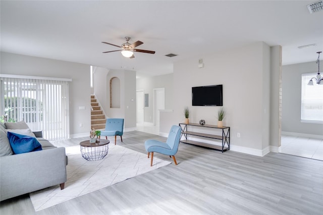 living room with a ceiling fan, visible vents, and light wood-style flooring