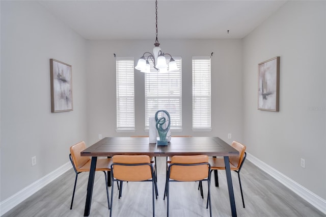 dining space with an inviting chandelier, light wood finished floors, and plenty of natural light