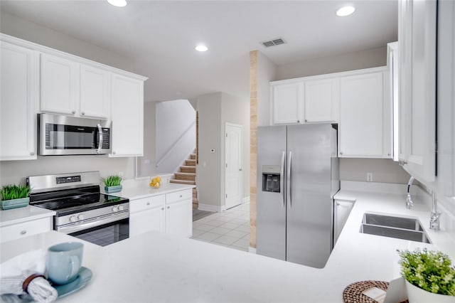 kitchen with light tile patterned flooring, white cabinets, stainless steel appliances, and sink