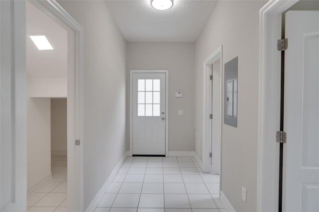 doorway to outside with light tile patterned floors, baseboards, electric panel, and a textured ceiling