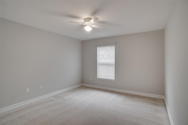 unfurnished room featuring ceiling fan, light carpet, and baseboards