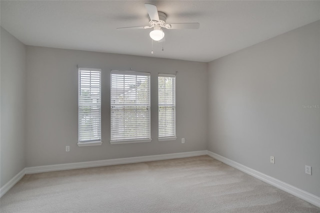 carpeted spare room featuring ceiling fan