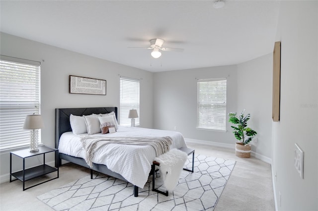 bedroom with light carpet, multiple windows, and ceiling fan