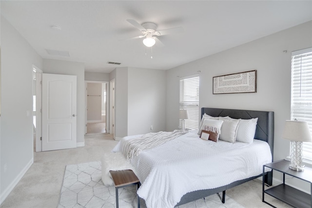 bedroom with light carpet, connected bathroom, and ceiling fan