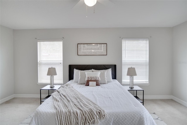 bedroom with baseboards, ceiling fan, and light carpet