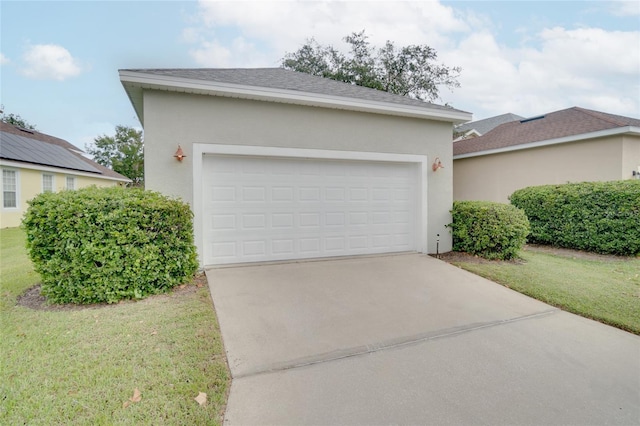 view of front of house with a shingled roof, stucco siding, a front yard, and concrete driveway