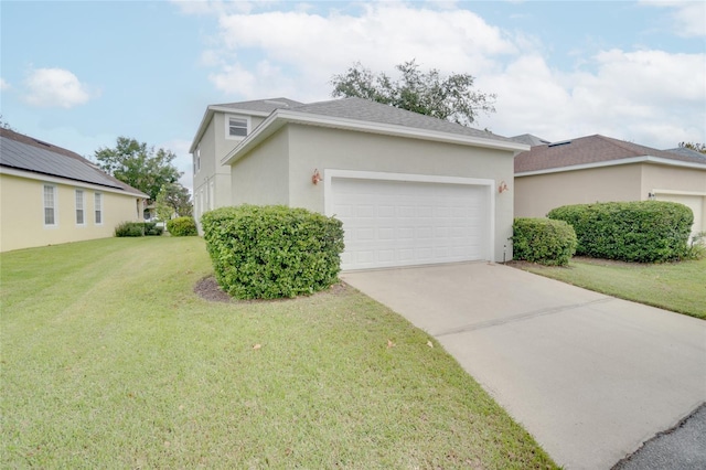 view of front of home featuring an attached garage, driveway, stucco siding, and a front yard