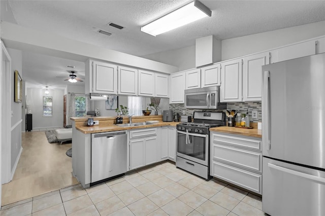 kitchen featuring tasteful backsplash, white cabinets, and stainless steel appliances