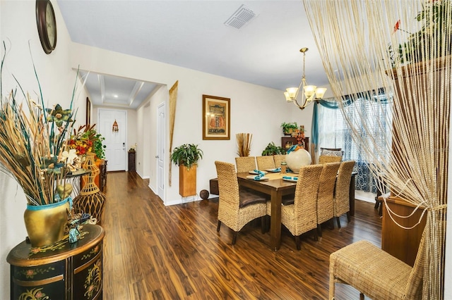 dining space with dark hardwood / wood-style flooring and an inviting chandelier