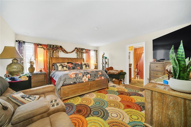 bedroom with hardwood / wood-style flooring and ensuite bath