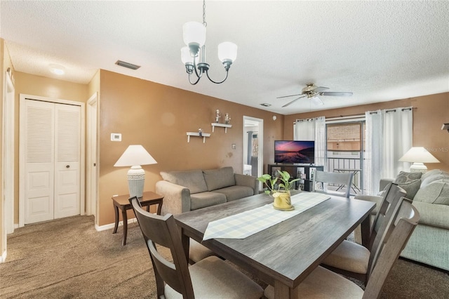 dining room with a textured ceiling, carpet floors, and ceiling fan with notable chandelier