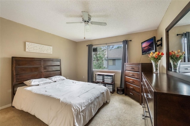 carpeted bedroom with ceiling fan and a textured ceiling