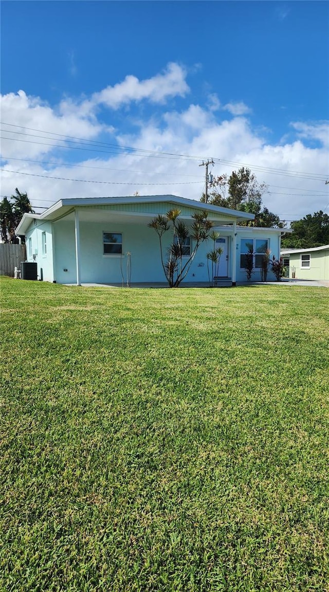 exterior space featuring central air condition unit and a lawn