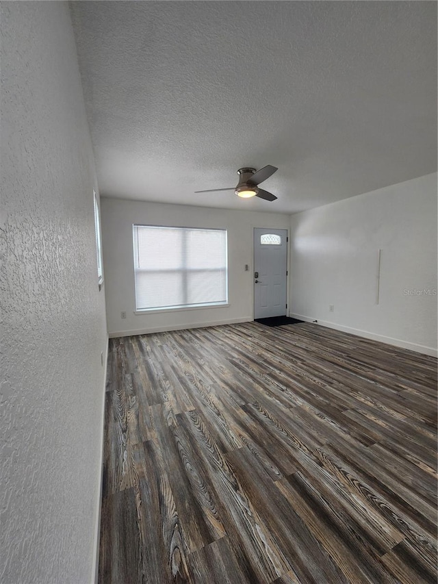 entrance foyer with ceiling fan, a textured ceiling, and dark hardwood / wood-style flooring